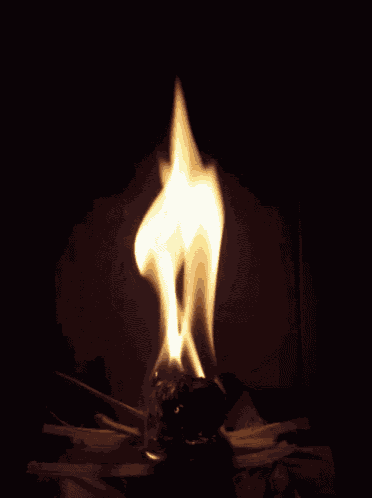a candle is burning in the dark and looks like a statue