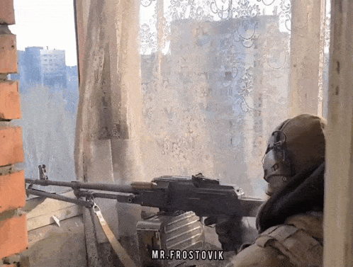 a man holding a machine gun in front of a window with the name mr. frostovik on the bottom right