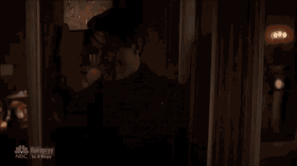 a man is standing in a dark room with a nbc logo on the bottom