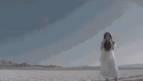 a close up of a woman 's face with long hair blowing in the wind .