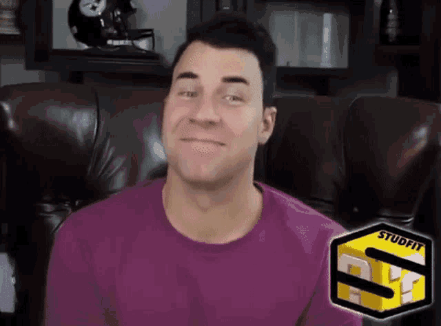 a man in a purple shirt is sitting in a chair with a studflix logo