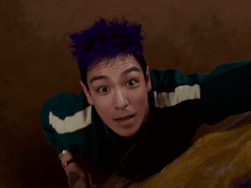 a man with purple hair is holding a spinner
