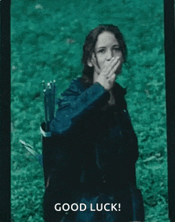a woman is covering her mouth with her hand while holding a bow and arrow in a field .