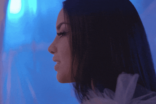 a close up of a woman 's face with a blue light in the background