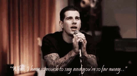 a man singing into a microphone with a quote behind him