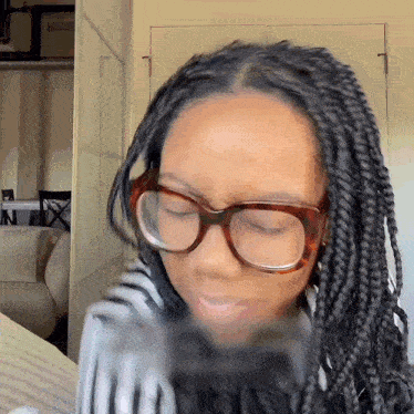 a woman with braids wearing glasses and a scarf