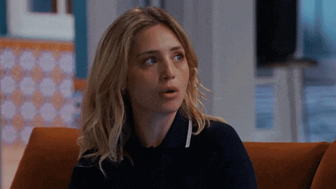 a woman is sitting on a couch with her mouth open and looking at the camera .