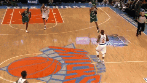 a basketball game is being played on a court that has the word knicks on it