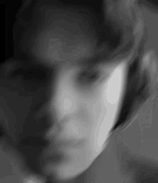 a close up of a person 's face in a blurry black and white photo