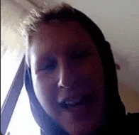 a close up of a person 's face with a hood on their head .