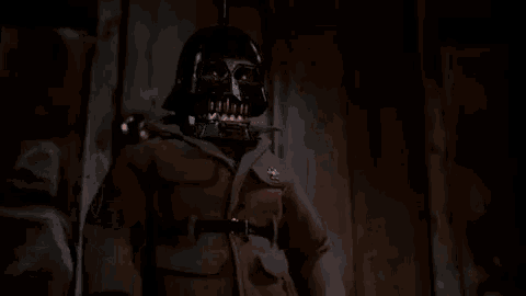 a robot with red lights on his eyes is wearing a helmet and a jacket .