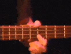 a close up of a person playing a guitar with a dark background