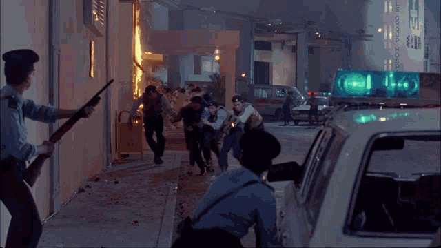a group of police officers are running towards a burning building