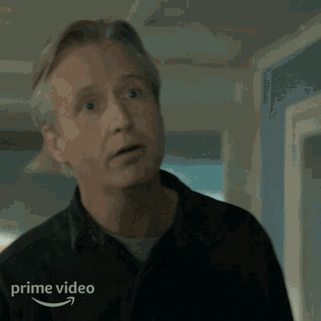 a man is making a funny face in front of an amazon prime video logo