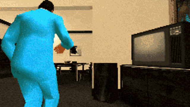 a man in a blue suit stands in front of a tv