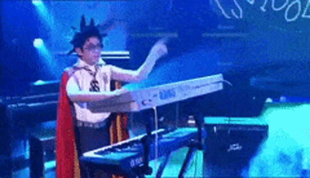 a person is playing a korg keyboard on a stage