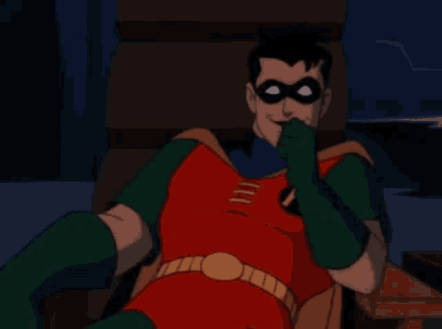 robin from the batman animated series is sitting in a chair and wearing a red and green costume .