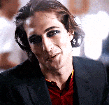 a close up of a man wearing a black jacket and red shirt
