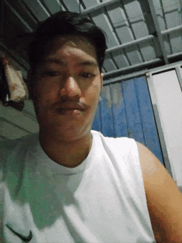 a man wearing a white nike tank top