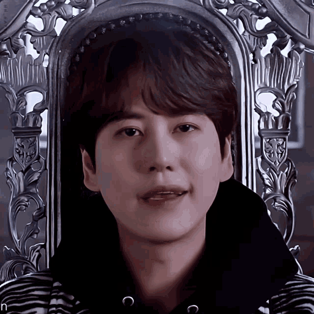 a close up of a person sitting in a chair with the letter n on the bottom right