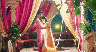 a man and a woman are hugging each other in a room with a lot of lights .