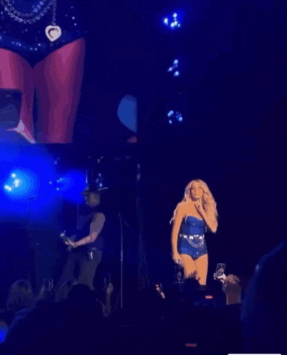 a woman in a blue swimsuit is dancing on stage