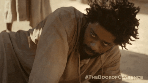 a man is laying on the ground with #thebookofclarence written on the bottom