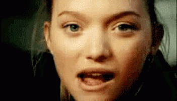 a woman is making a funny face with her mouth open .