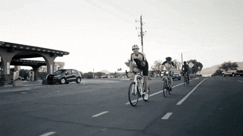 a group of people riding bicycles down a road