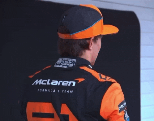 a man wearing a mclaren formula 1 team jacket and hat