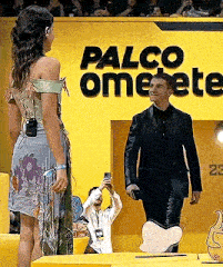 a man in a suit is standing next to a woman in a dress .