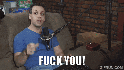 a man sitting on a couch with a microphone and the words fuck you