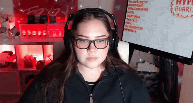 a girl wearing headphones and glasses is looking at the camera