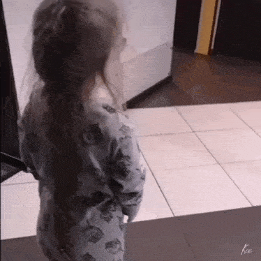 a little girl wearing a sweater with owls on the sleeves