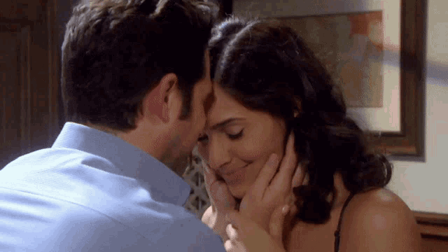 a man and woman are kissing in front of a picture