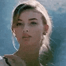a close up of a woman 's face with a ponytail .