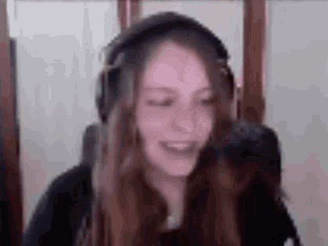 a woman wearing headphones is sitting in front of a computer screen .