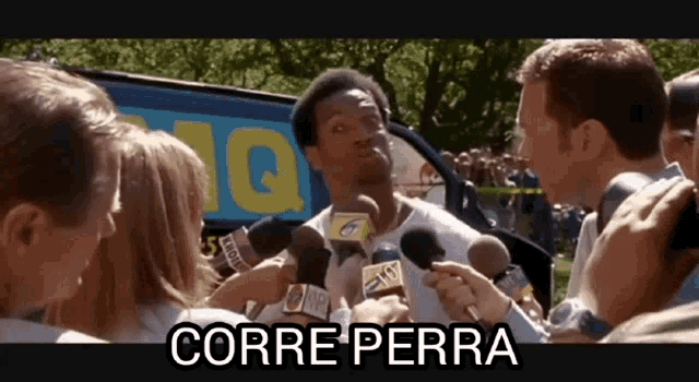 a man is being interviewed by a group of reporters with the words corre perra written above him