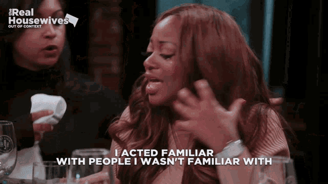 a woman sitting at a table with a sign that says real housewives out of context