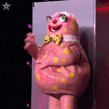 a pink and yellow clown with a bow tie is standing in front of a star