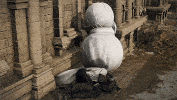 a man laying on the ground next to a statue