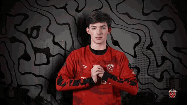 a man wearing a red jersey with the word rib on it stands with his hands folded
