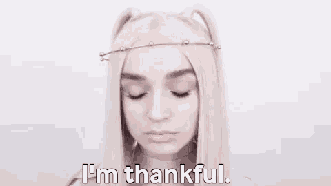 a woman with white hair is wearing a headband and saying i 'm thankful .