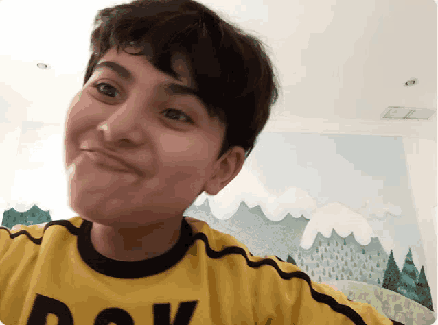 a young boy wearing a yellow shirt that says dok on it