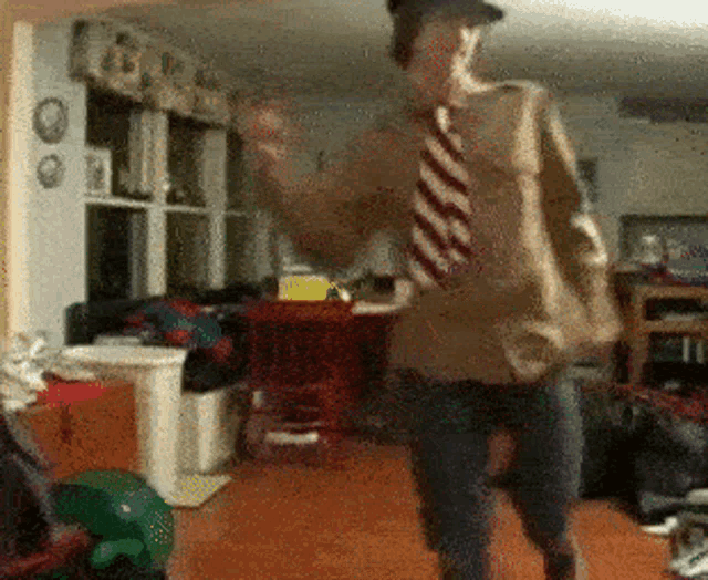 a man wearing a striped tie is dancing in a messy room