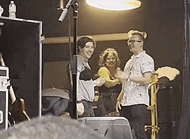 a group of people are standing on a stage in a room .