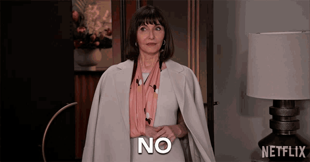 a woman is standing in front of a lamp with the word no on her chest