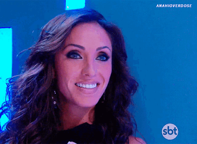 a woman is smiling with a sbt logo in the corner