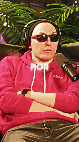 a man wearing headphones and sunglasses has the word prince on his hoodie
