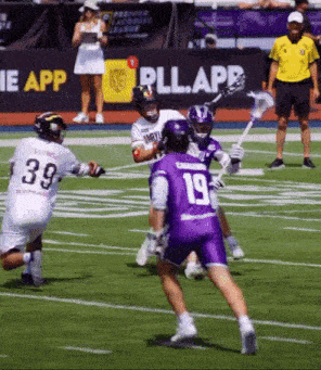 a lacrosse player in purple shorts has the number 19 on the back of his jersey